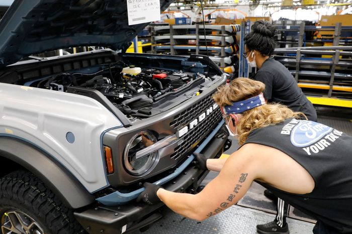 Two people fixing a vehicle